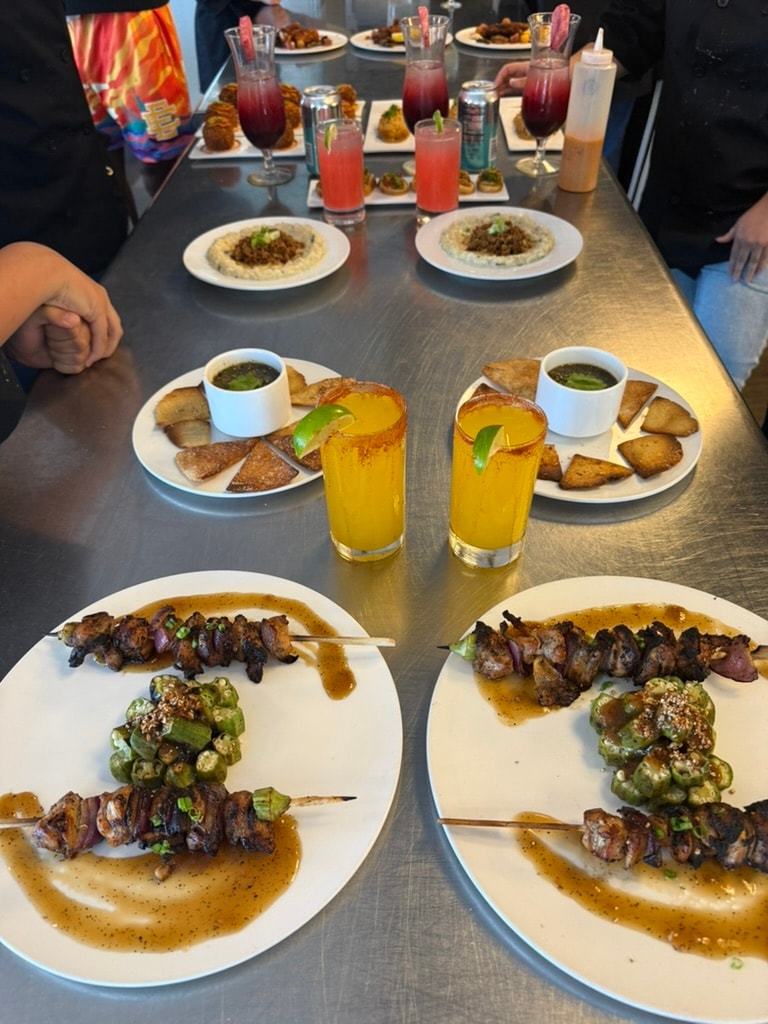 Student-prepared skewers, sides, sauces, and colorful drinks arranged for presentation