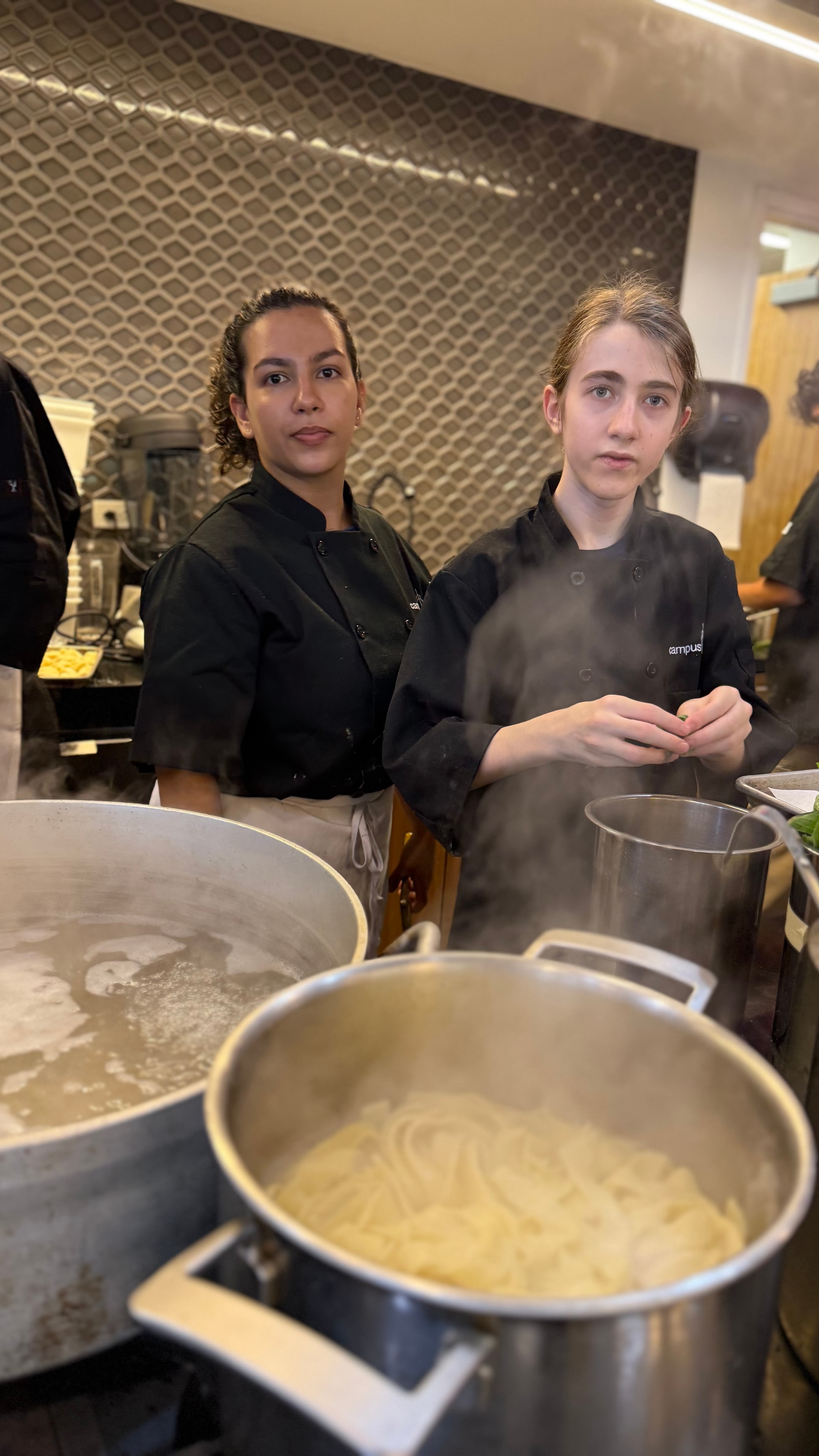 Campers cooking together in a professional kitchen