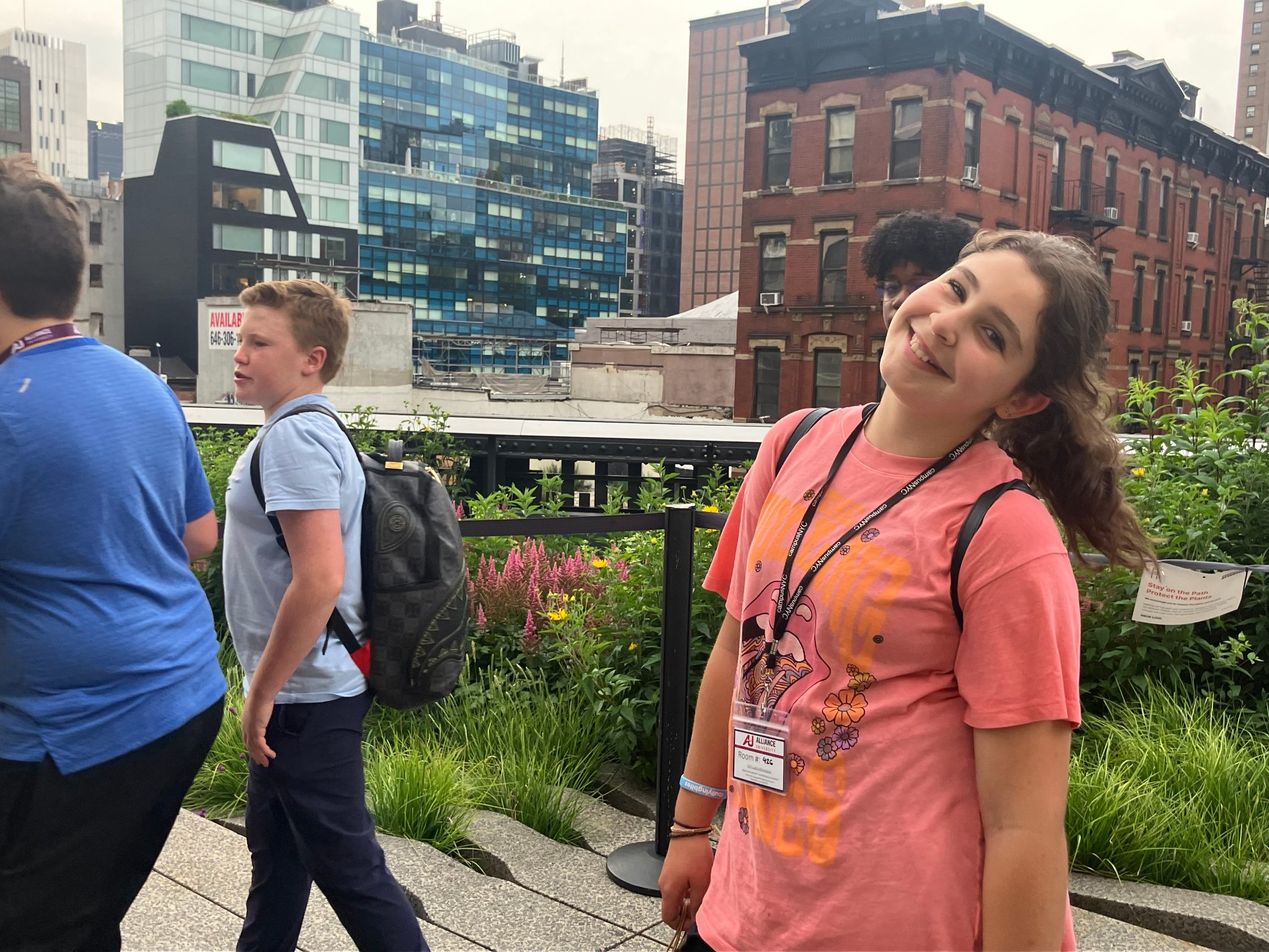 Camper smiling on the High Line with NYC skyline
